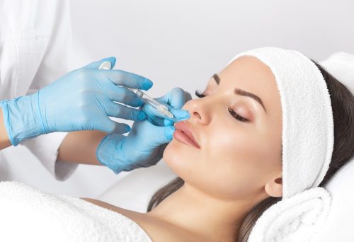 a woman having dermal fillers injected into her lips