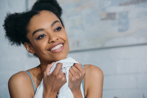 a woman holding a towel wondering what her skin type is.
