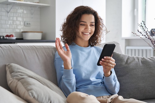 a young woman looking and using beauty and skincare apps on her phone