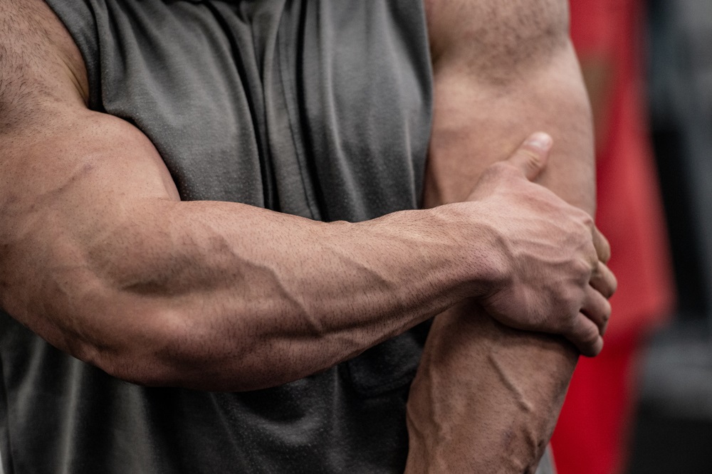 strong man with big-muscles holding hispainful elbow